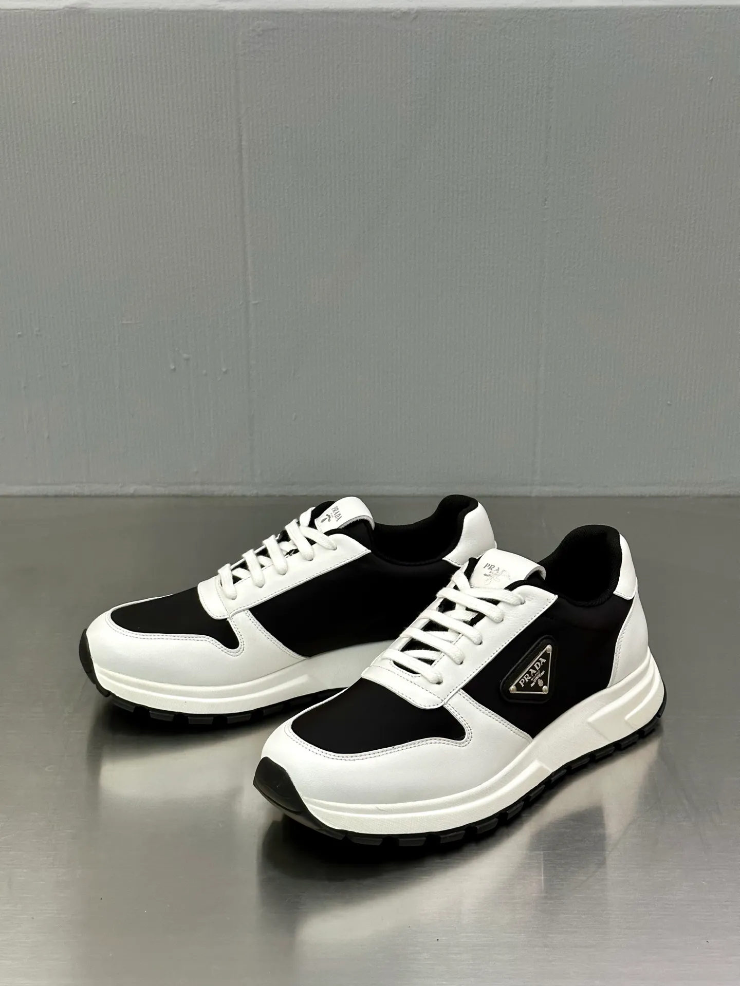 💰740 Prada/Prada men's new mesh stitching sneakers. This sneaker presents a modern version, reinterpreting the brand's archive style with clean lines and smooth details. The shoes are made of calf leather and technical fabric, with a triangular metal logo on the outside, bright TPU decoration on the heel, and a longer and padded inner heel design for a more comfortable fit. The tongue is decorated with a silk-screen logo, and is paired with a hollow rubber sole on the heel. The full cowhide lining comes standard with logo cowhide foot pads, making the upper foot taller, more comfortable, and versatile! Comes with full original packaging! Size: 39-40-41-42-43-44 standard leather shoe size (45 can be customized and does not support returns)